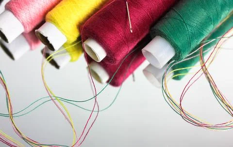 Multicolored threads in the coils reflected on the surface of the mirror flat Stock Photos