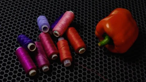 Multicolored threads on a dark background, red bell pepper close-up from above Stock Photos