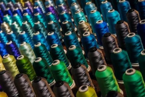 Multicolored threads on industrial spindles Stock Photos