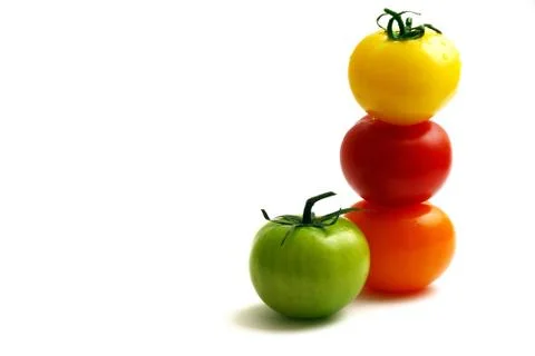 Multicolored tomatoes placed one upon the other Stock Photos