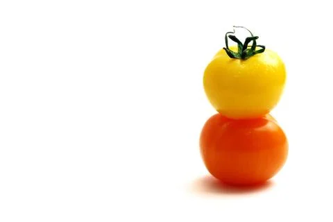 Multicolored tomatoes placed one upon the other Stock Photos