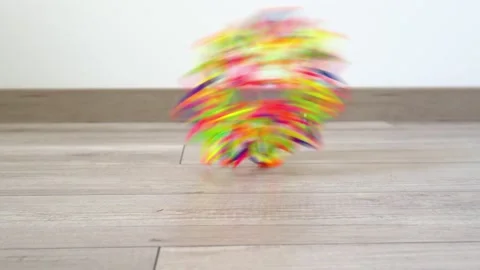 A multicolored toy (puzzle ball) rolls quickly on the floor from right to left 動画素材 130490664