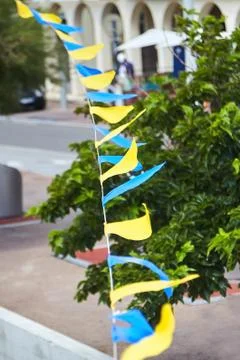 Multicolored triangular festival flags on green trees background Stock-Fotos