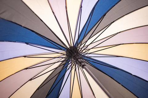 Multicolored umbrella opening, vibrant pattern and symmetry from a low angle Stock Photos