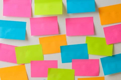Multicolored various notes post-it on a white wall Stock Photos