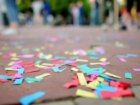 Multicolour paper ticker-tape lies on the ground after celebration Stock Photos