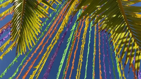Multicolour ribbons decorating the street in front of blue sky and palm leaves. 스톡 동영상 227851083