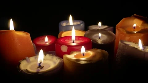Multicoloured candles burn on a black background. C0205 Stock Footage 255198677