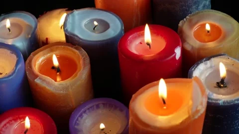 Multicoloured candles burn on a black background. C0209 Stock Footage 255199109