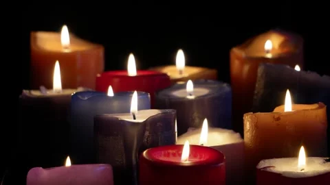 Multicoloured candles burn on a black background. C0229 Stock Footage 255211545