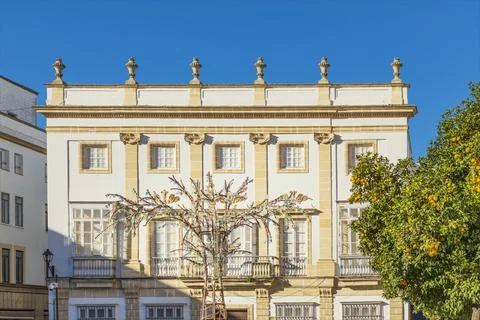 Multicoloured metal tree shape against a white colonial building Stock Photos
