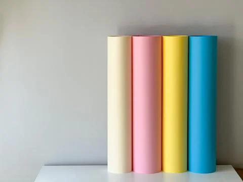 Multicoloured paper in rolls on a simple background Fotos Stock