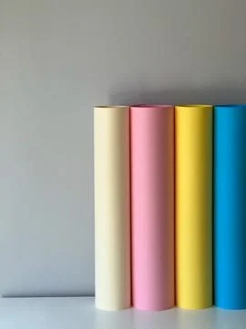 Multicoloured paper in rolls on a simple background Stock Photos