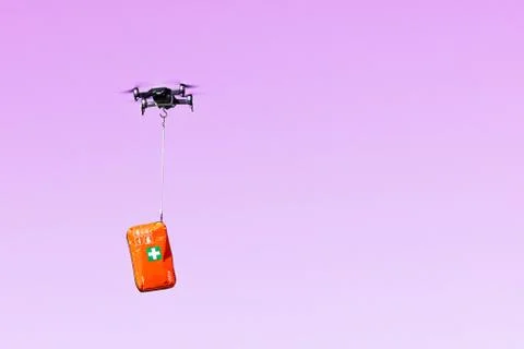 Multicopter drone flying with a first aid kit isolated on a pink background,  Foto stock
