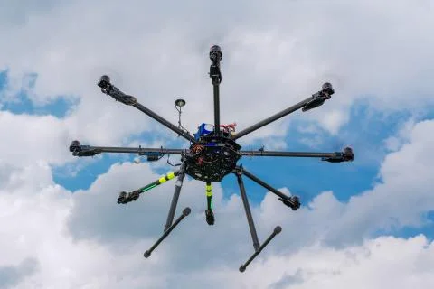 Multicopter in flight on sky and clouds background Stock Photos