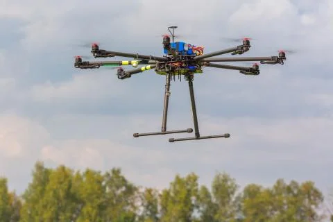 Multicopter in flight on trees background copter Stock Photos