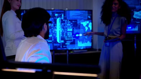 Multicultural business and engineering team discussing software Stock Footage 340562960