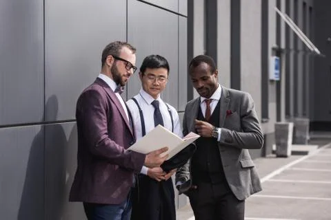 Multicultural business team discussing work together near modern office build Stock Photos