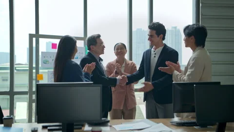 Multicultural business team standing around a desk and talking Vídeos de archivo 339063254