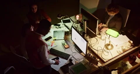 Multicultural businesspeople work late, analyzing reports and discussing Stock Footage 271214067