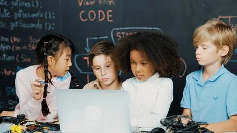 Multicultural children using laptop programing engineering code. Erudition. 库存照片