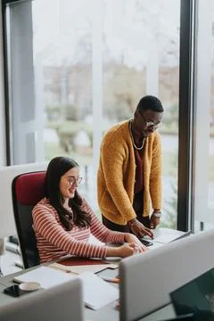 Multicultural colleagues collaborating in a modern office environment. Stock Photos