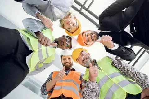 Multicultural construction team in protective helmet at work Stock Photos