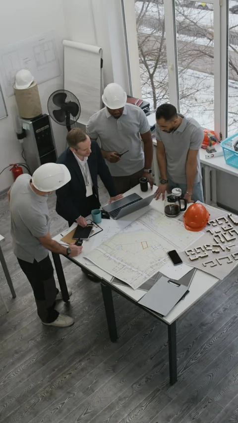Multicultural Construction Workers Analyzing Blueprints in Office Stock Footage 329624863