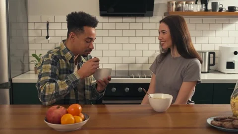 Multicultural couple having breakfast in the kitchen. Video stock 305651588