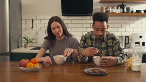 Multicultural couple having breakfast at the kitchen table. Video stock 305652840