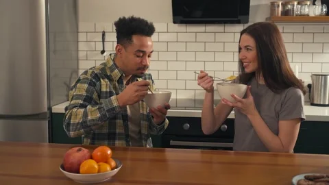 Multicultural couple having breakfast together at the kitchen table. Video stock 305651830