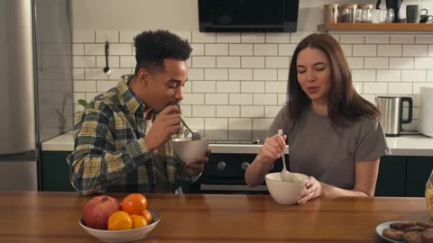 Multicultural couple having breakfast together in a bright kitchen. Stock Footage 305652019