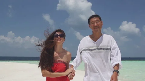 Multicultural Couple Holds Hands Lovingly While Walking Along Romantic Island Stock Footage 45856846