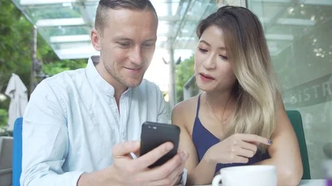 Multicultural couple using app on smartphone together Stock Footage 79482298