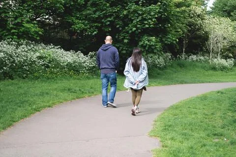 A multicultural couple walking on a footpath in Figgate Park in Edinburgh i.. Stock Photos