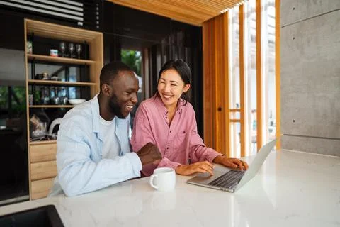 Multicultural couple working remotely, planning finances and investments. D.. Stock Photos