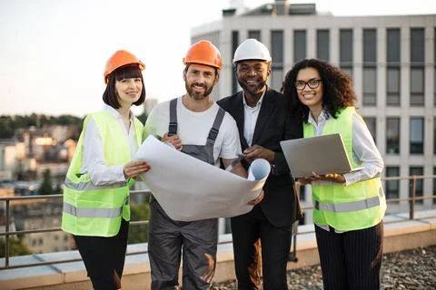 Multicultural developers smiling at camera on terrace Stock Photos