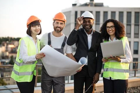 Multicultural developers smiling at camera on terrace Stock Photos