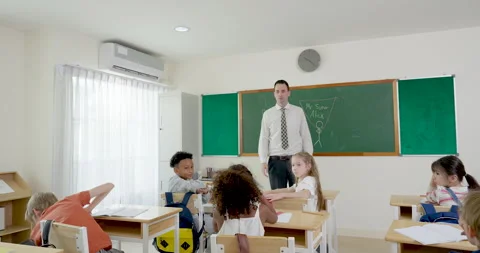 Multicultural elementary pupil group raises arms during math question time as Stock Footage 337465853