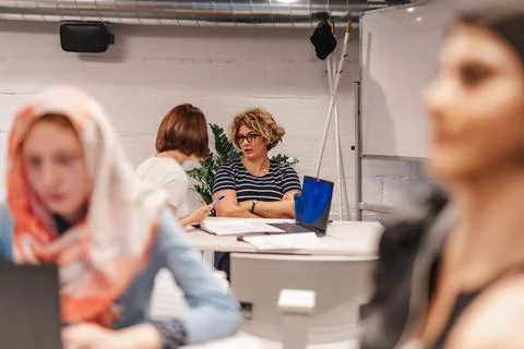 Multicultural employees working in groups at modern classroom. Learning Stock Photos