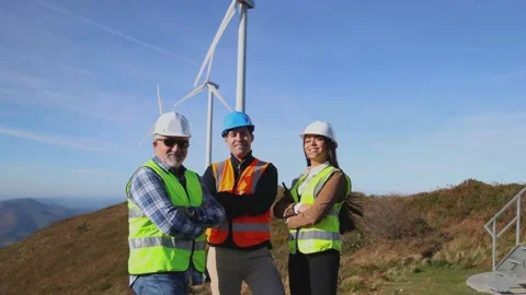 Multicultural engineers team posing with arms crossed by wind turbine Stock Footage 294976080
