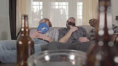 Multicultural friends sleeping on the sofa after watching boxing on TV. Empty Stock Footage 106458976