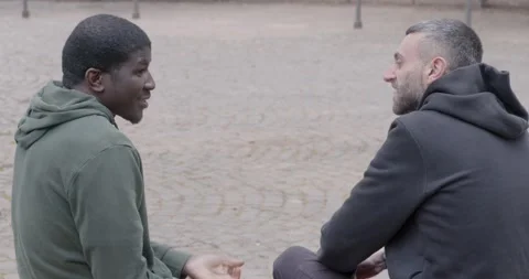 Multicultural friends talk happily in park seen from behind Stock Footage 333198462