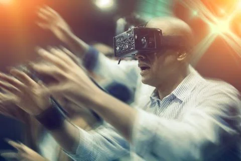 Multicultural friends using virtual reality headsets.Light laser effect Stock Photos