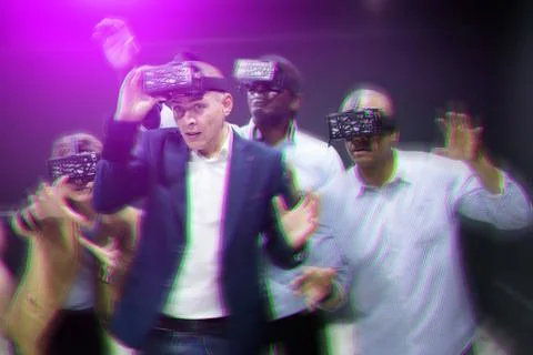 Multicultural friends using virtual reality headsets.Light laser effect Stock Photos