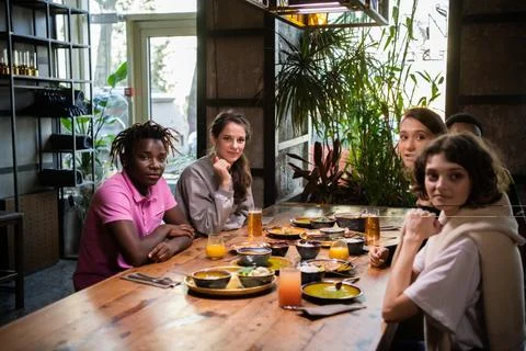 A multicultural group of friends spending time in a cafe, everyo Stock-Fotos