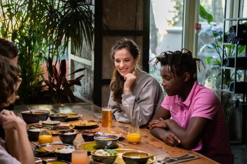 A multicultural group of students in a cafe, eating asian food, Stock Photos