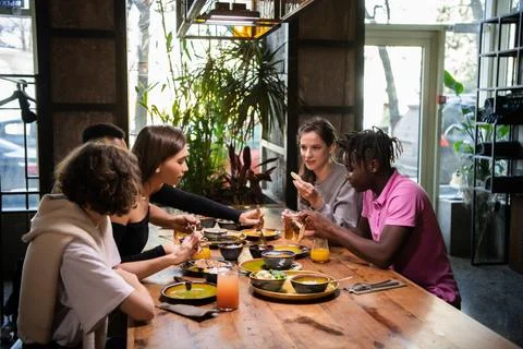 A multicultural group of students in a cafe, eating asian food, Stock Photos