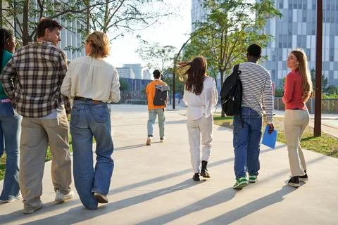 Multicultural group of students walking going out of university, leaving to go Stock Photos