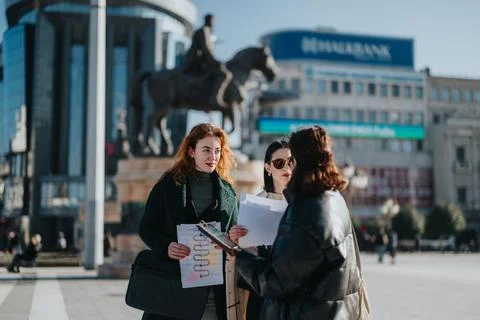 Multicultural group of women collaborating on a project in an urban setting Stock Photos
